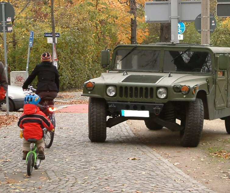 Bild mit Autofahrer und Fahrradtrainer auf dem Gehweg